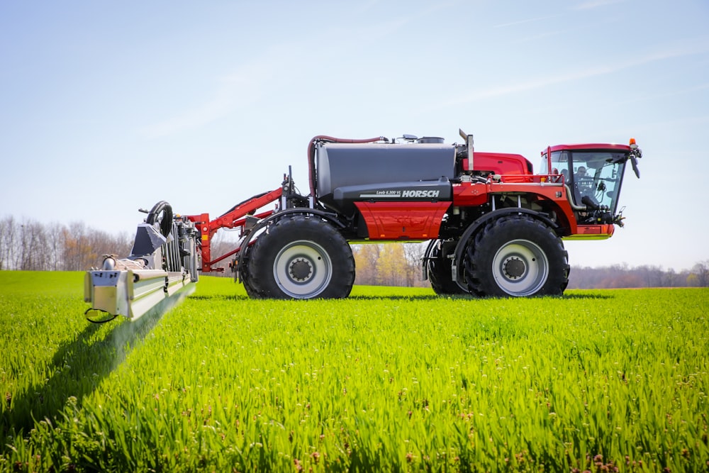 a red tractor in a green field with a blue sky in the background