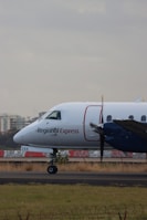 A regional jet taxiing on the runway against a backdrop of clear blue skies.