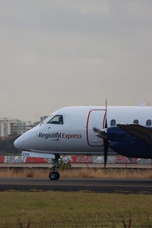 A regional jet taxiing on the runway against a backdrop of clear blue skies.