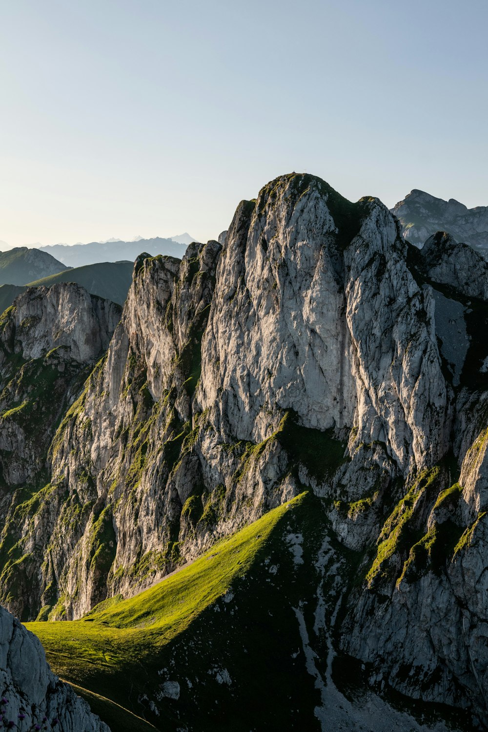 a grassy area in the middle of a mountain range