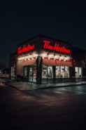 a tim hortons store lit up at night