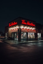 a tim hortons store lit up at night