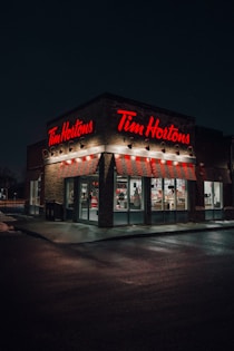 a tim hortons store lit up at night