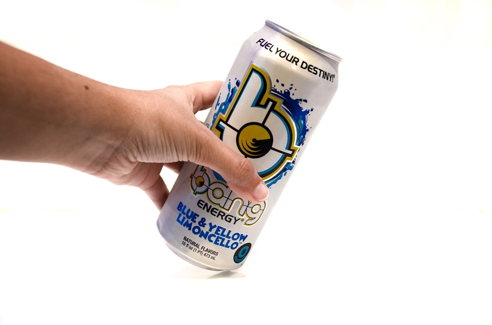 a hand holding a can of energy drink