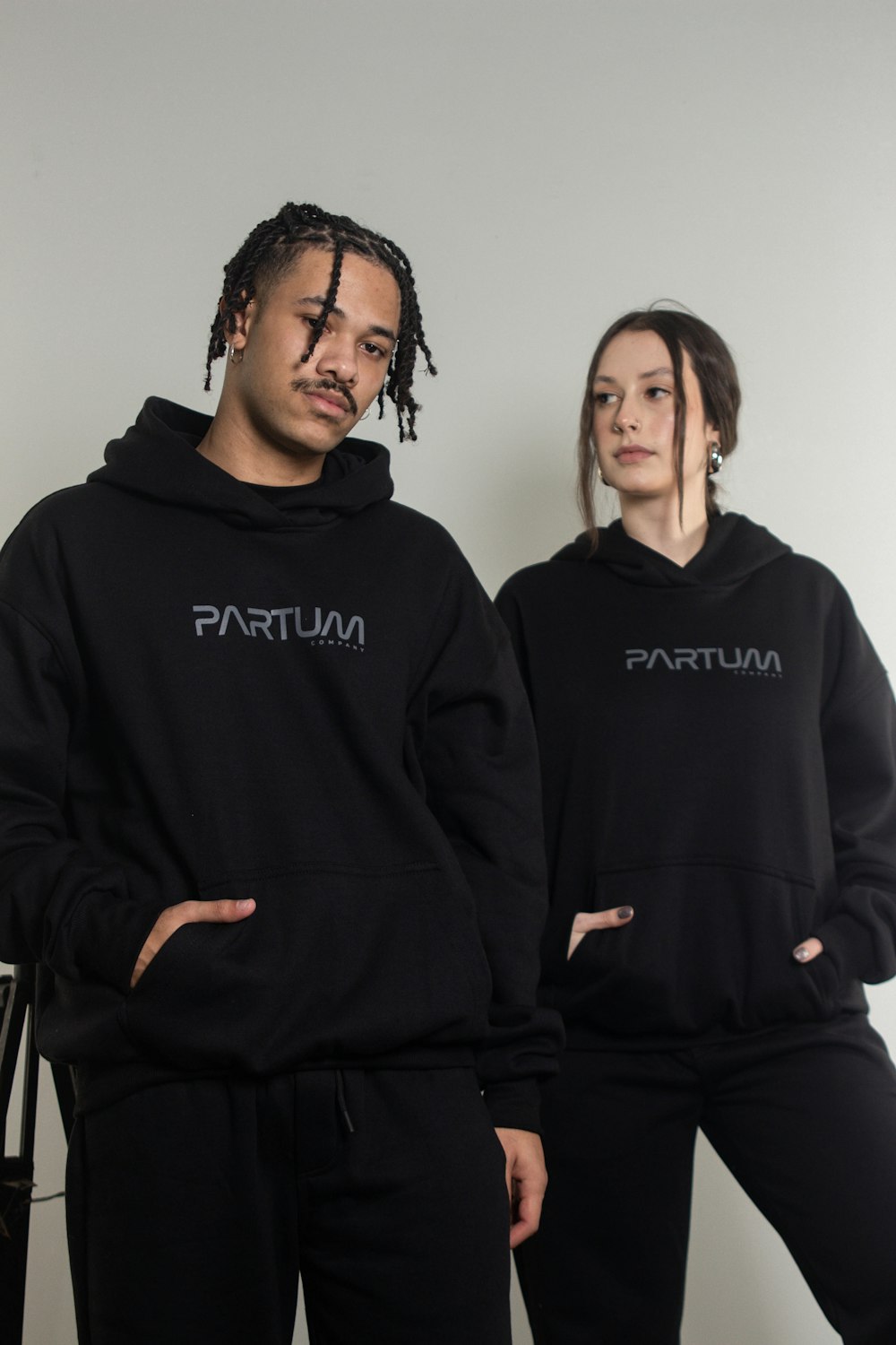 a man and a woman wearing black sweatshirts