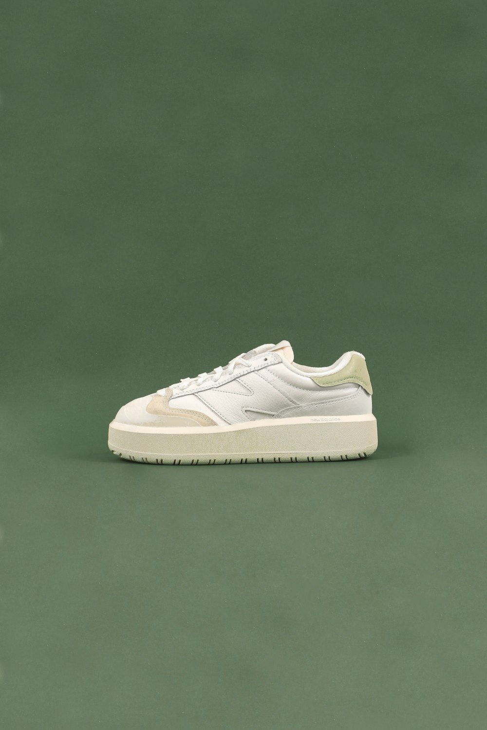a white tennis shoe on a green surface