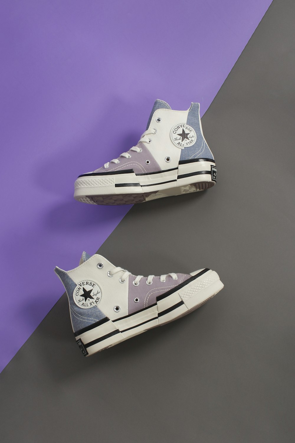 a pair of converse sneakers on a purple and purple background