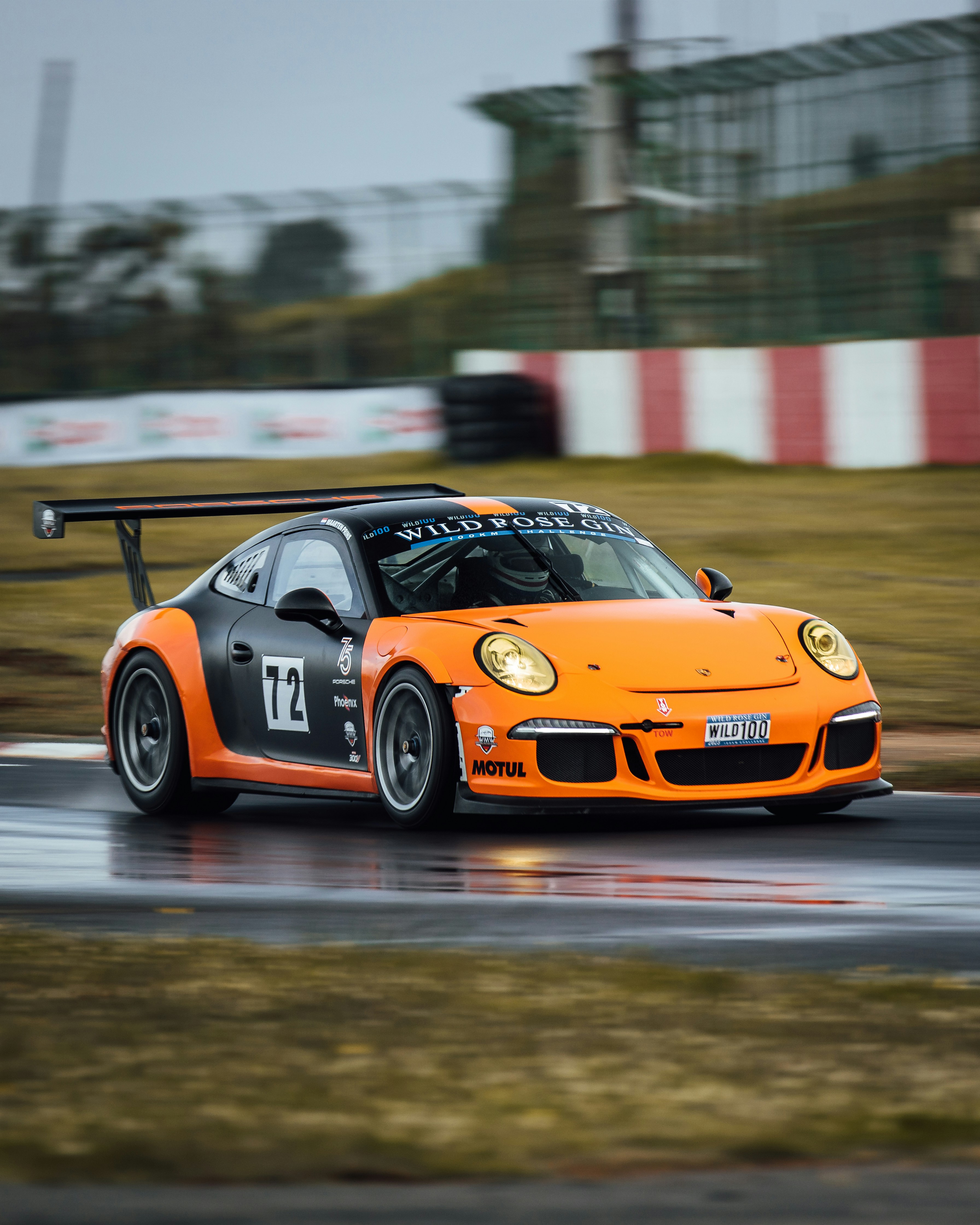 an orange sports car driving on a race track