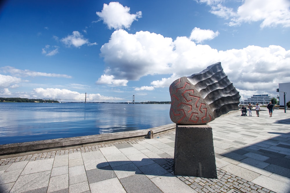 a sculpture of a person's head on a brick walkway next to a body