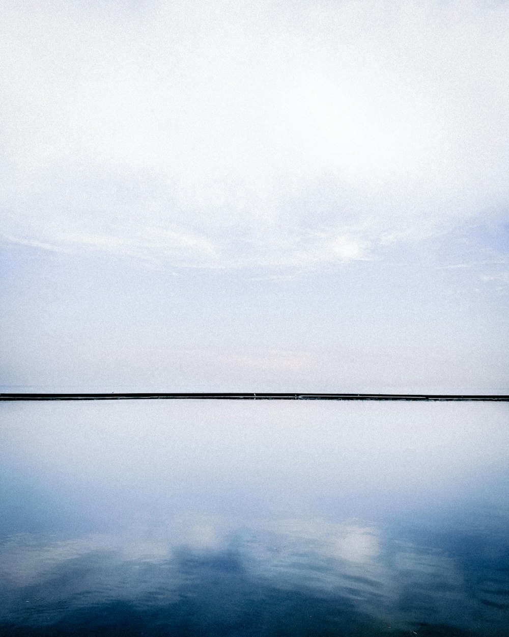 a large body of water sitting under a cloudy sky