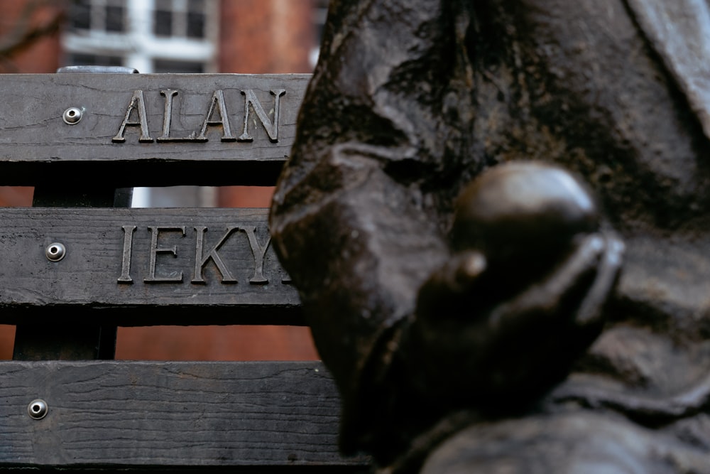 a close up of a statue of a person sitting on a bench