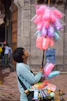 a man holding a bunch of balloons on a street