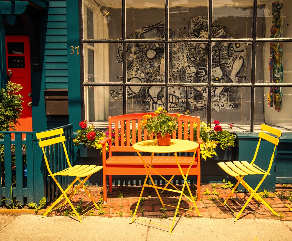 a couple of chairs and a table in front of a building