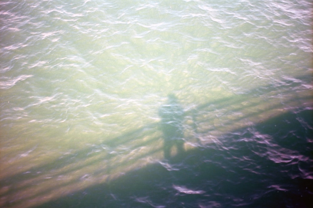 a shadow of a person standing in the water