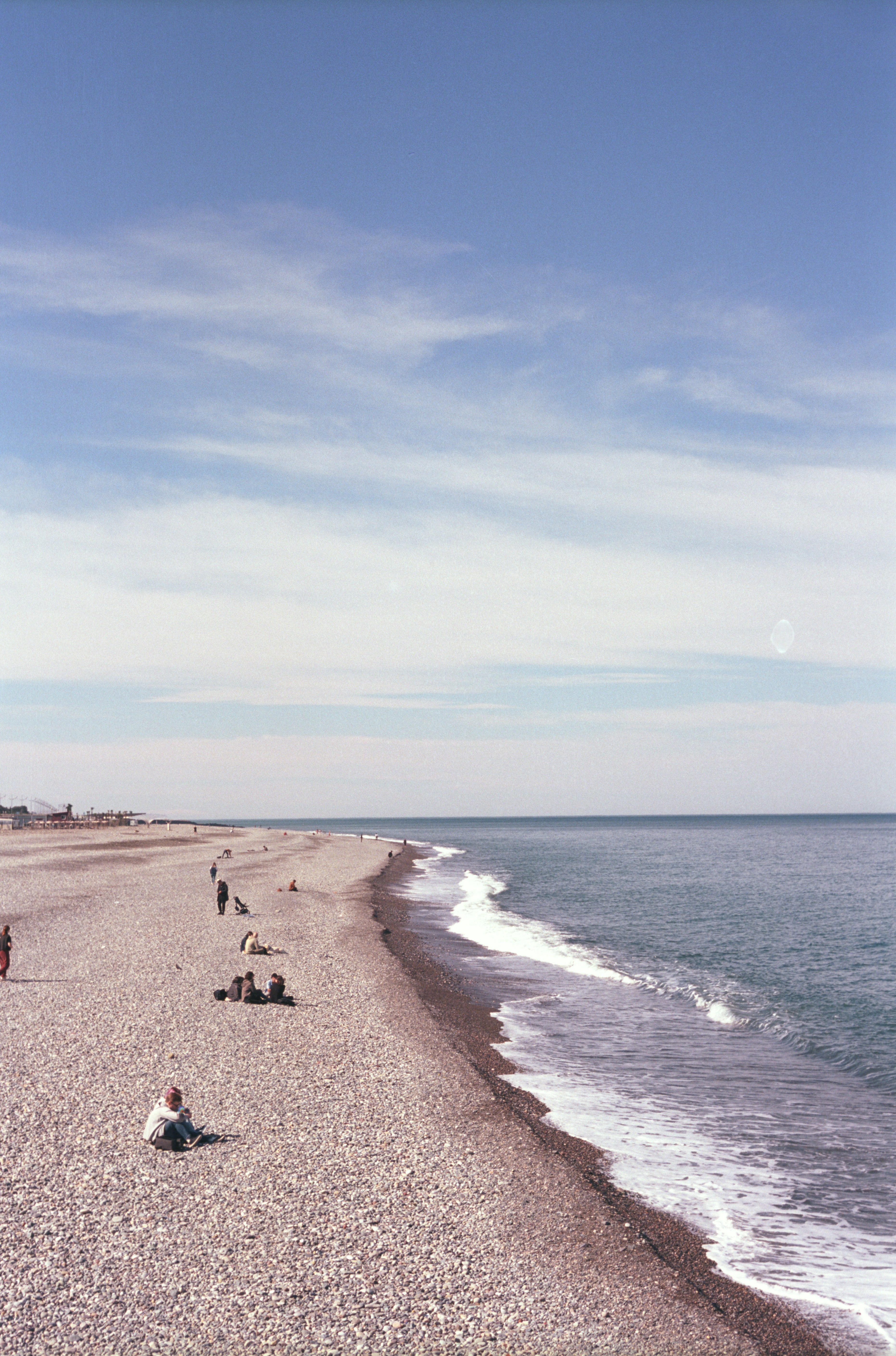 a group of people sitting on top of a beach next to the ocean