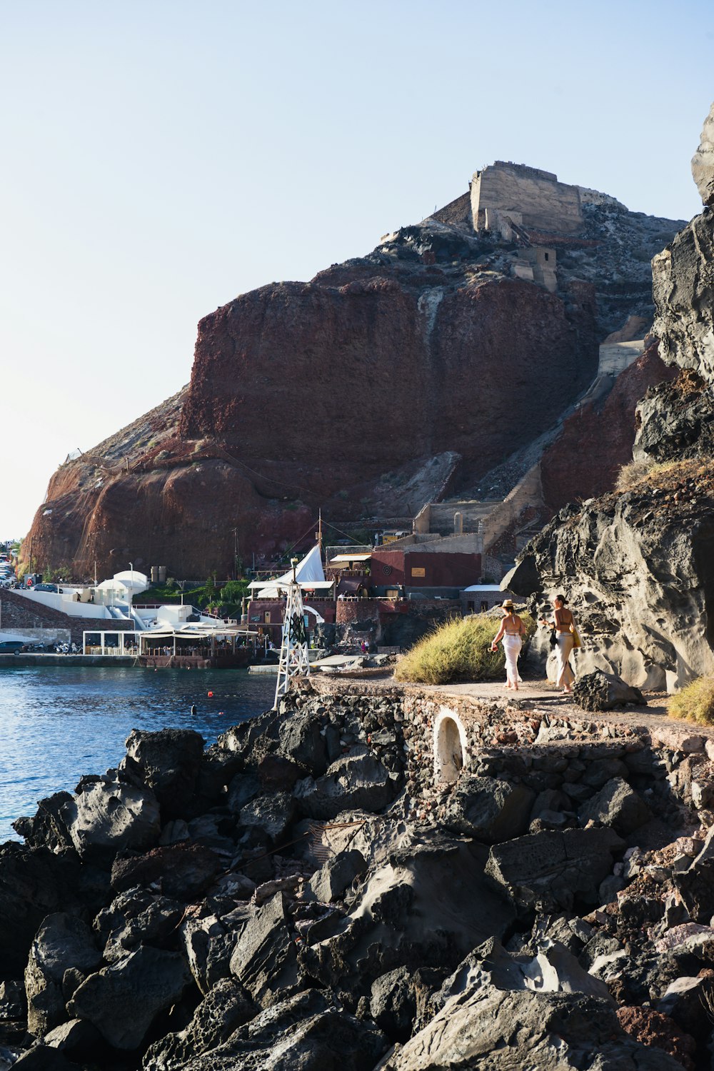 a group of people walking along a rocky shore