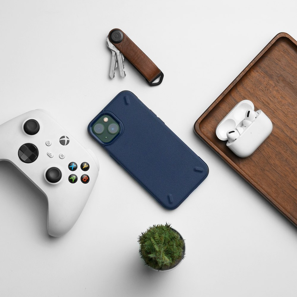 a cell phone case next to a controller and a plant