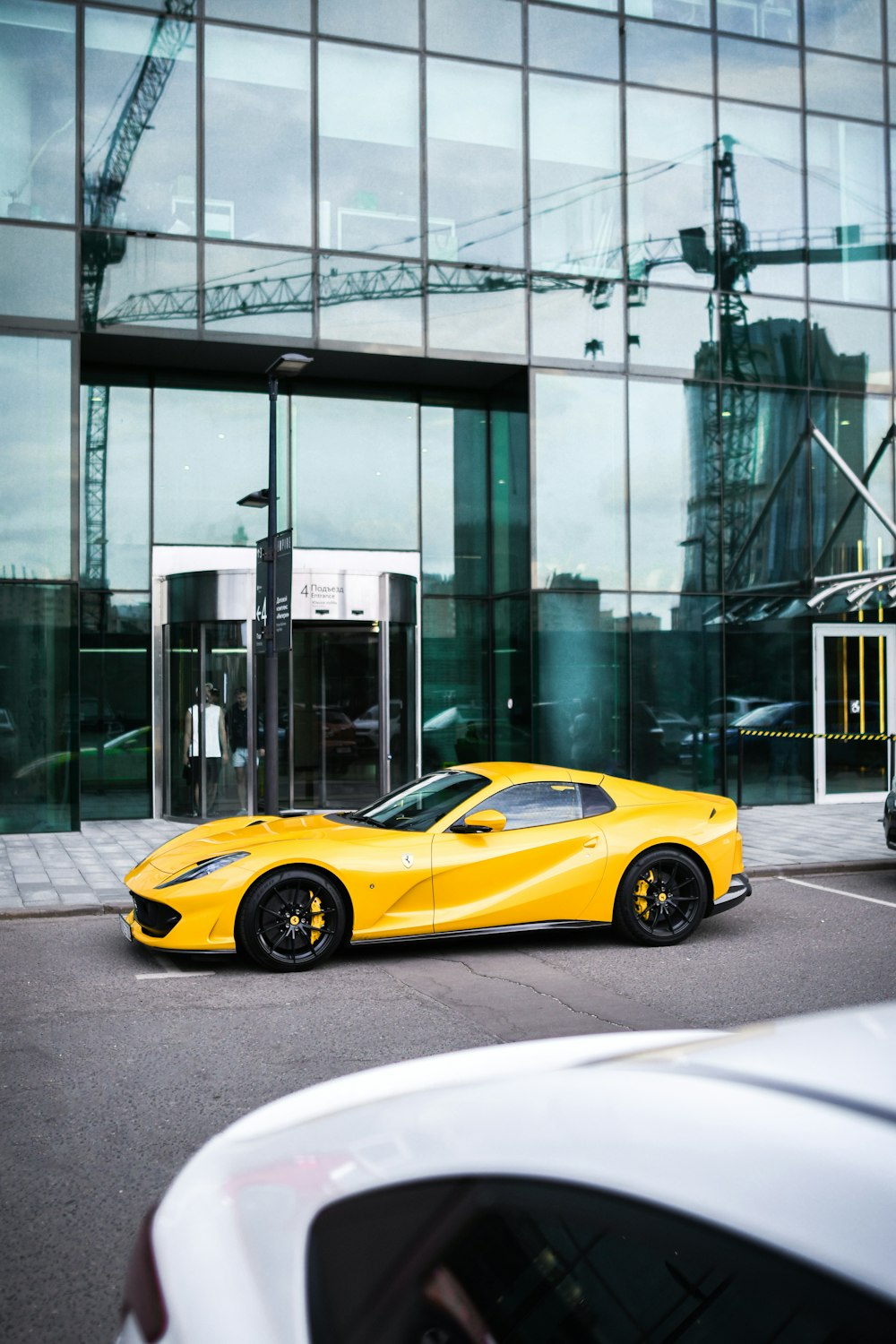 a yellow sports car parked in front of a building