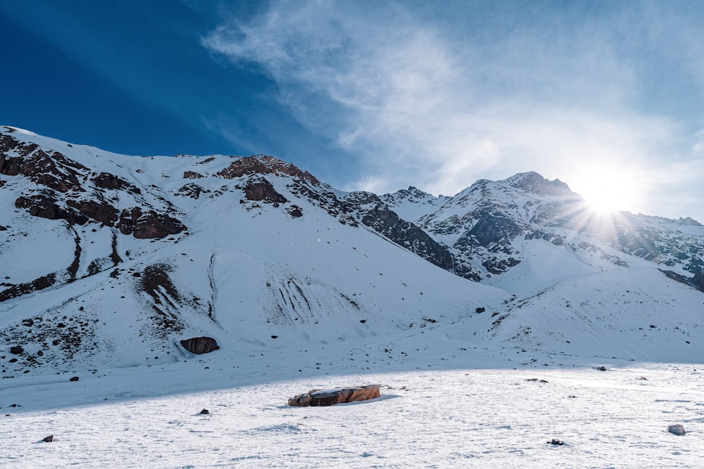 the sun is shining on a snowy mountain