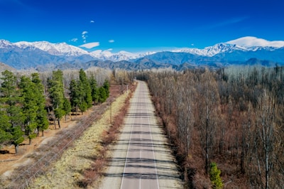a long empty road with mountains in the background