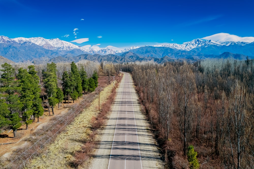 a long empty road with mountains in the background