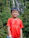 A happy young man wearing a local football team jersey, smiling outdoors.
