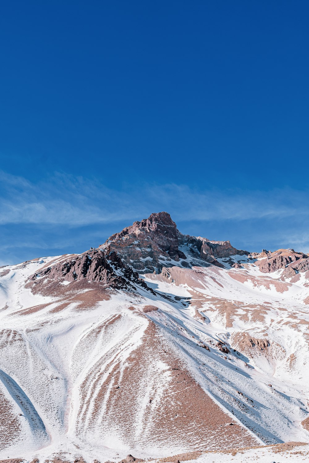 Una montagna coperta di neve sotto un cielo blu