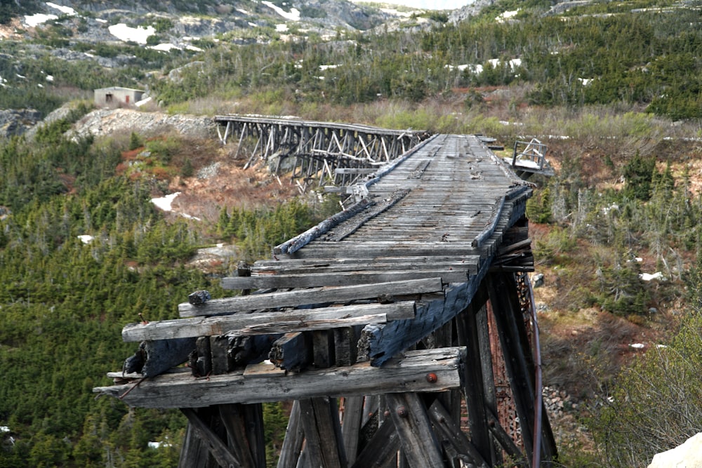 an old wooden bridge with a mountain in the background