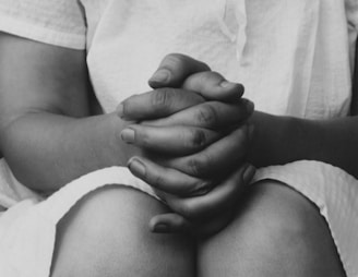 a black and white photo of a person holding their hands together