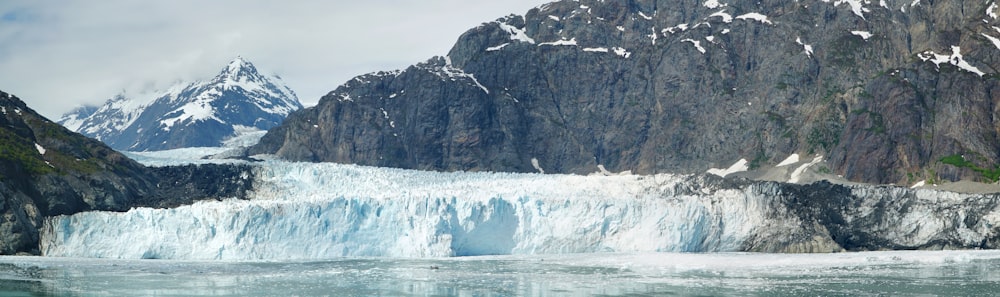 a large glacier with mountains in the background