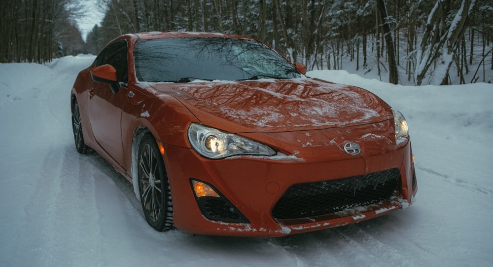 a red sports car parked on a snowy road
