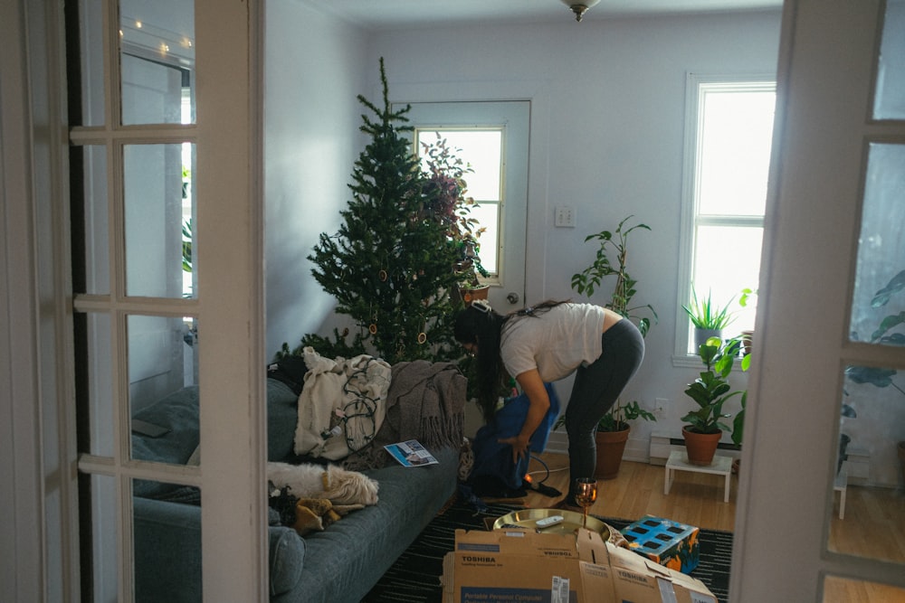 a woman bending over a couch in a living room