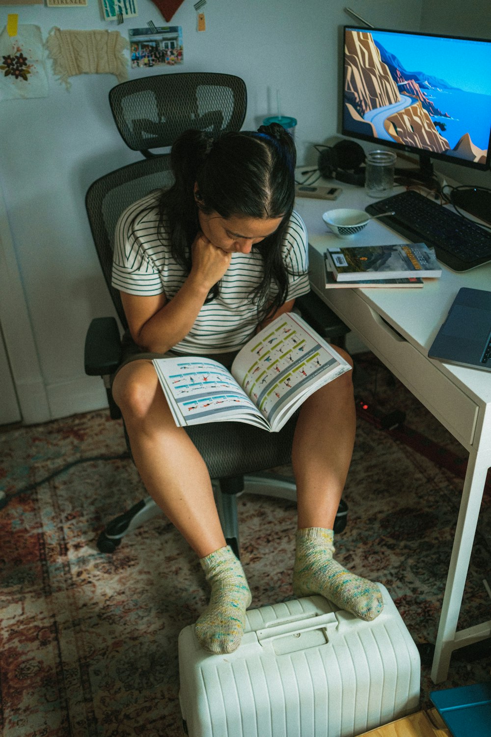 a woman sitting in a chair reading a book