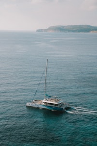A sleek modern catamaran sailing smoothly on turquoise Caribbean waters under a bright blue sky.