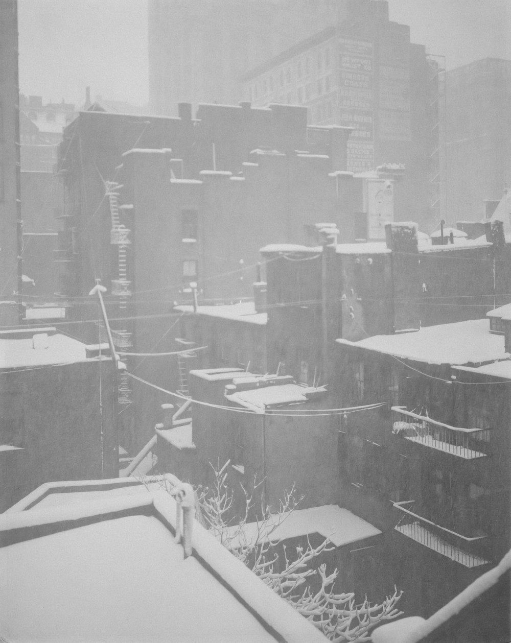 a black and white photo of a snowy city