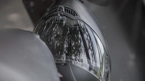 A close-up of a sleek motorcycle helmet with a reflective visor under natural sunlight