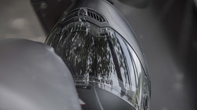 Close-up of a sleek motorcycle helmet with reflective visor on a workshop bench