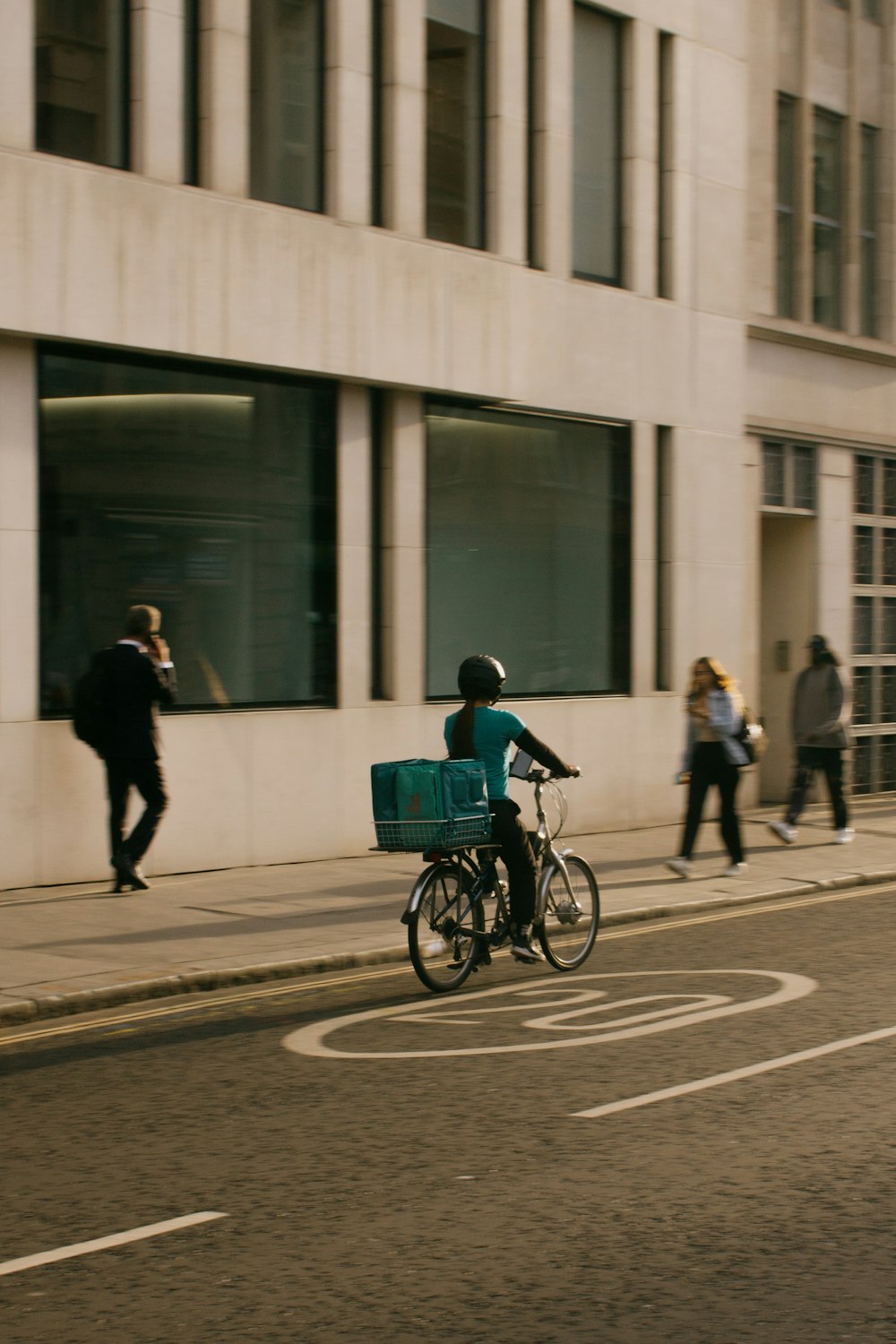 a man riding a bike down a street next to a tall building