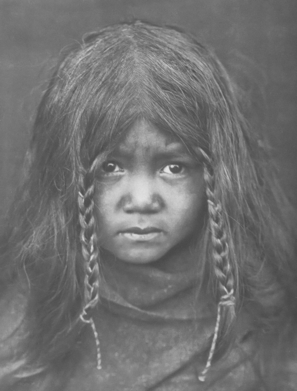 a black and white photo of a young girl with long hair