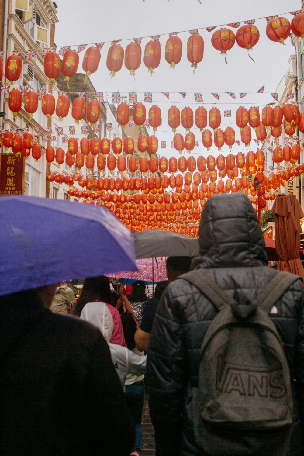 a group of people walking down a street with umbrellas