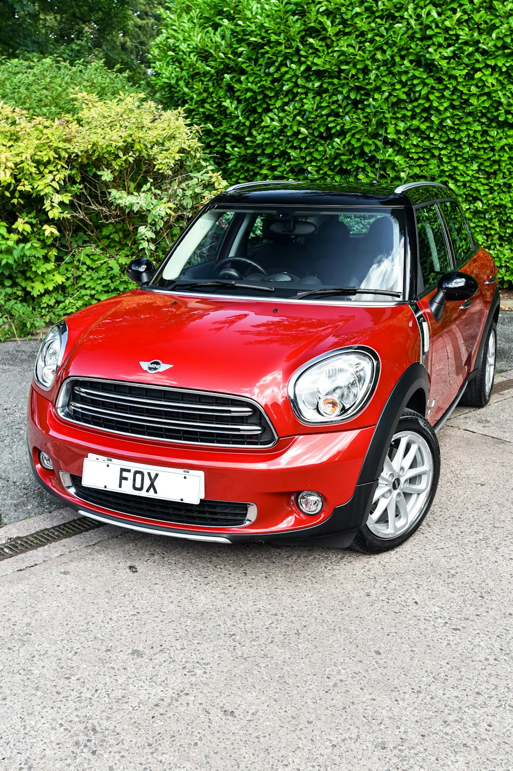 a small red car parked on the side of the road