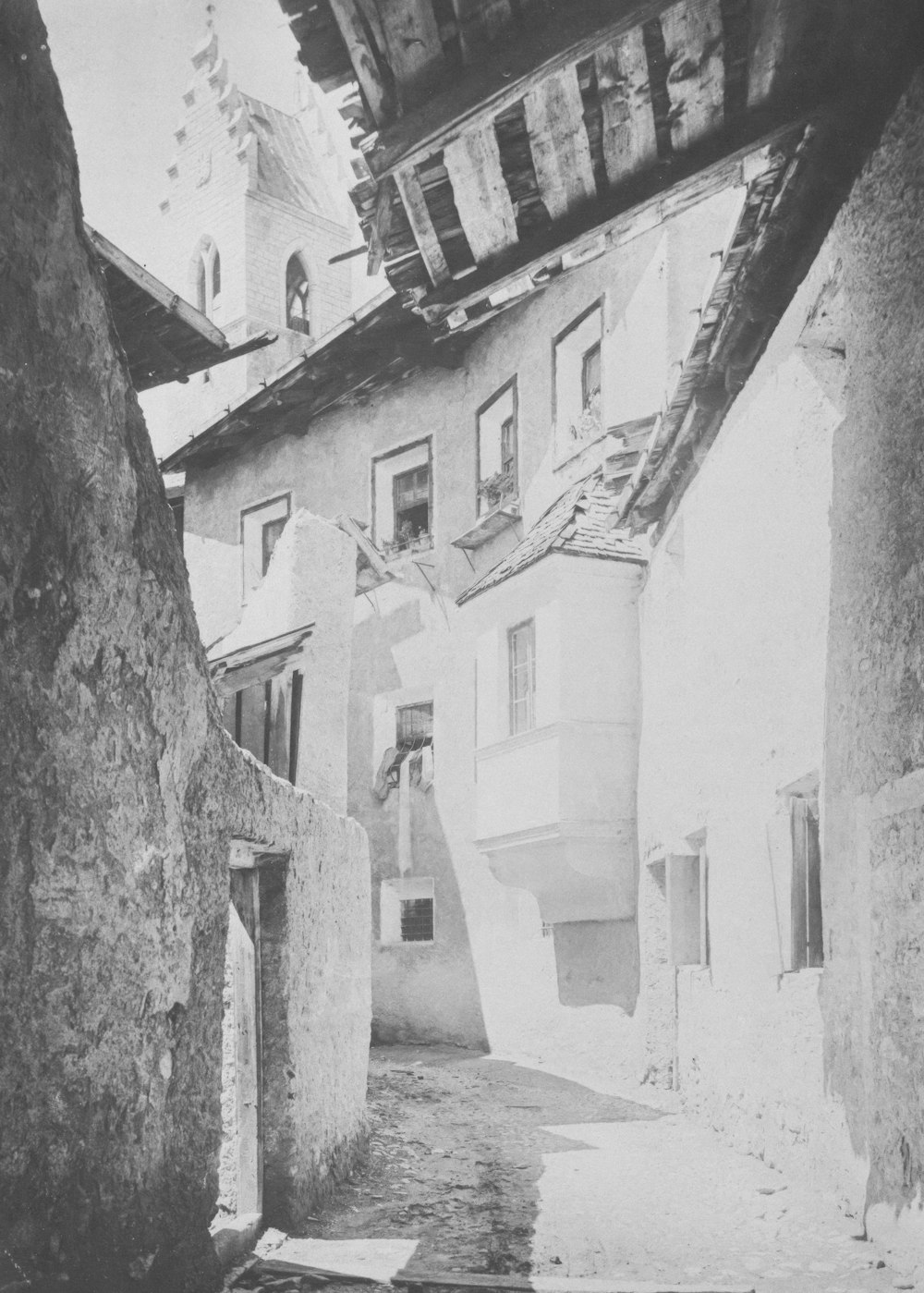 a black and white photo of a narrow street