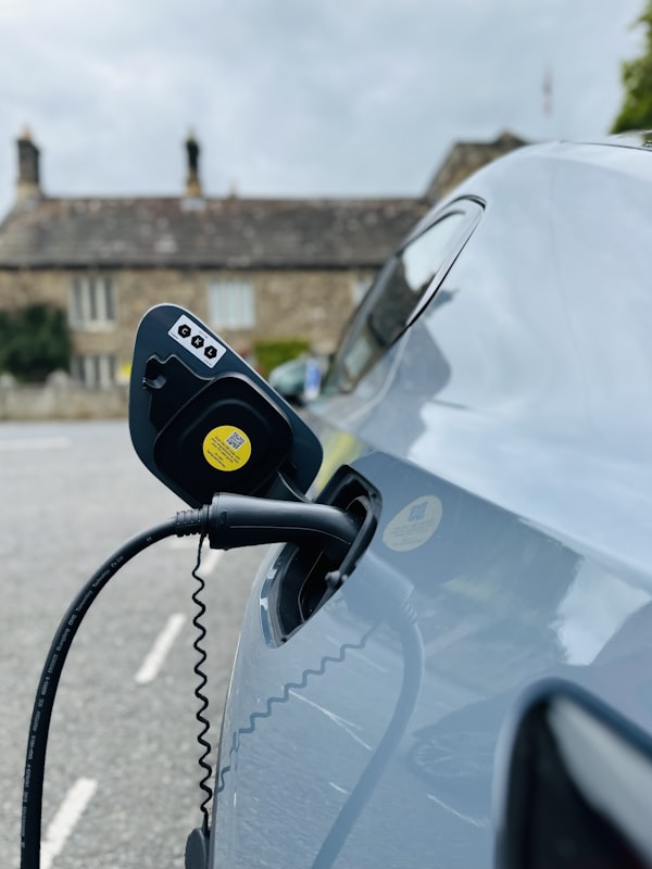 Electric car plugged into a charger in a public parking area