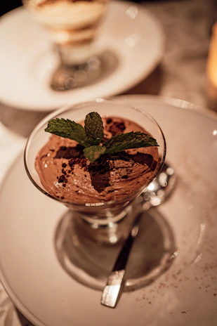 Close-up of a luscious chocolate avocado mousse topped with fresh berries and mint leaves, showcasing a guilt-free dessert.