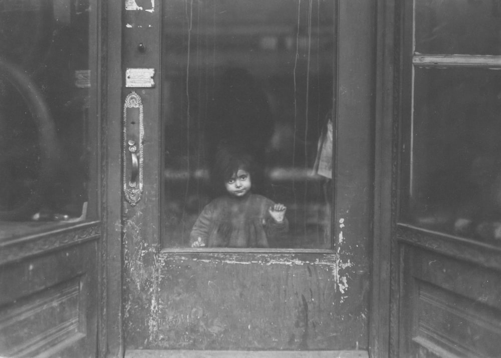 a young boy is looking out the window of a train