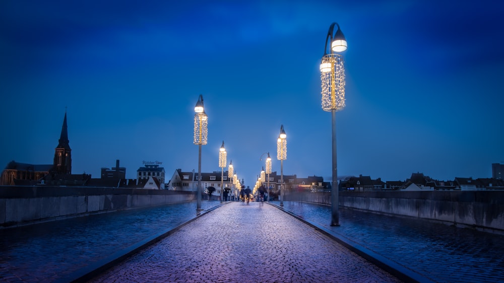 people walking across a bridge at night