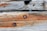 Weathered wooden beams with visible grain patterns and rusted metal bolts. The wood shows signs of aging and some areas of decay.