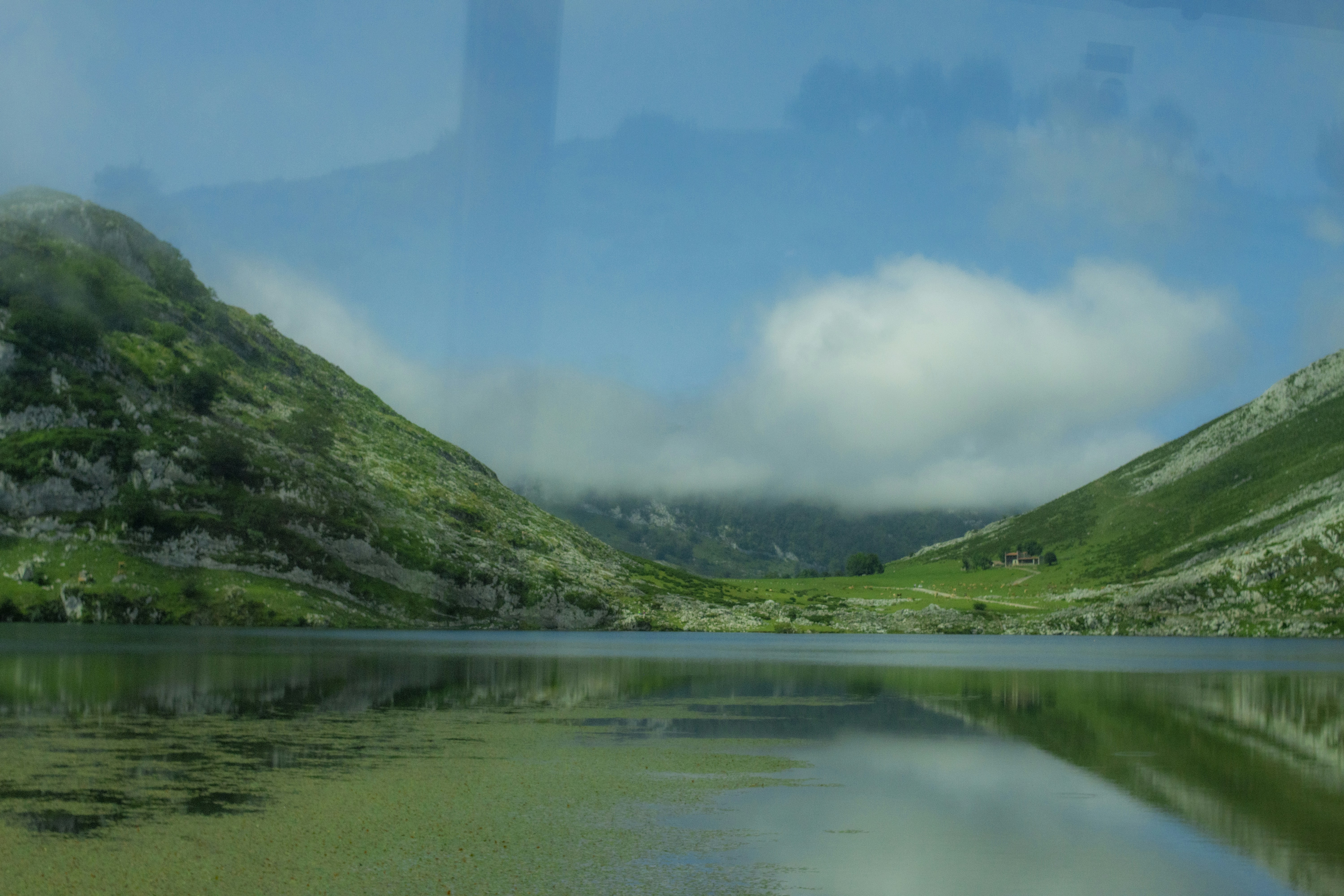 a body of water surrounded by mountains and clouds, Lagos de Covadonga