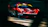 Dynamic shot of a red sports car speeding on a racetrack during sunset.