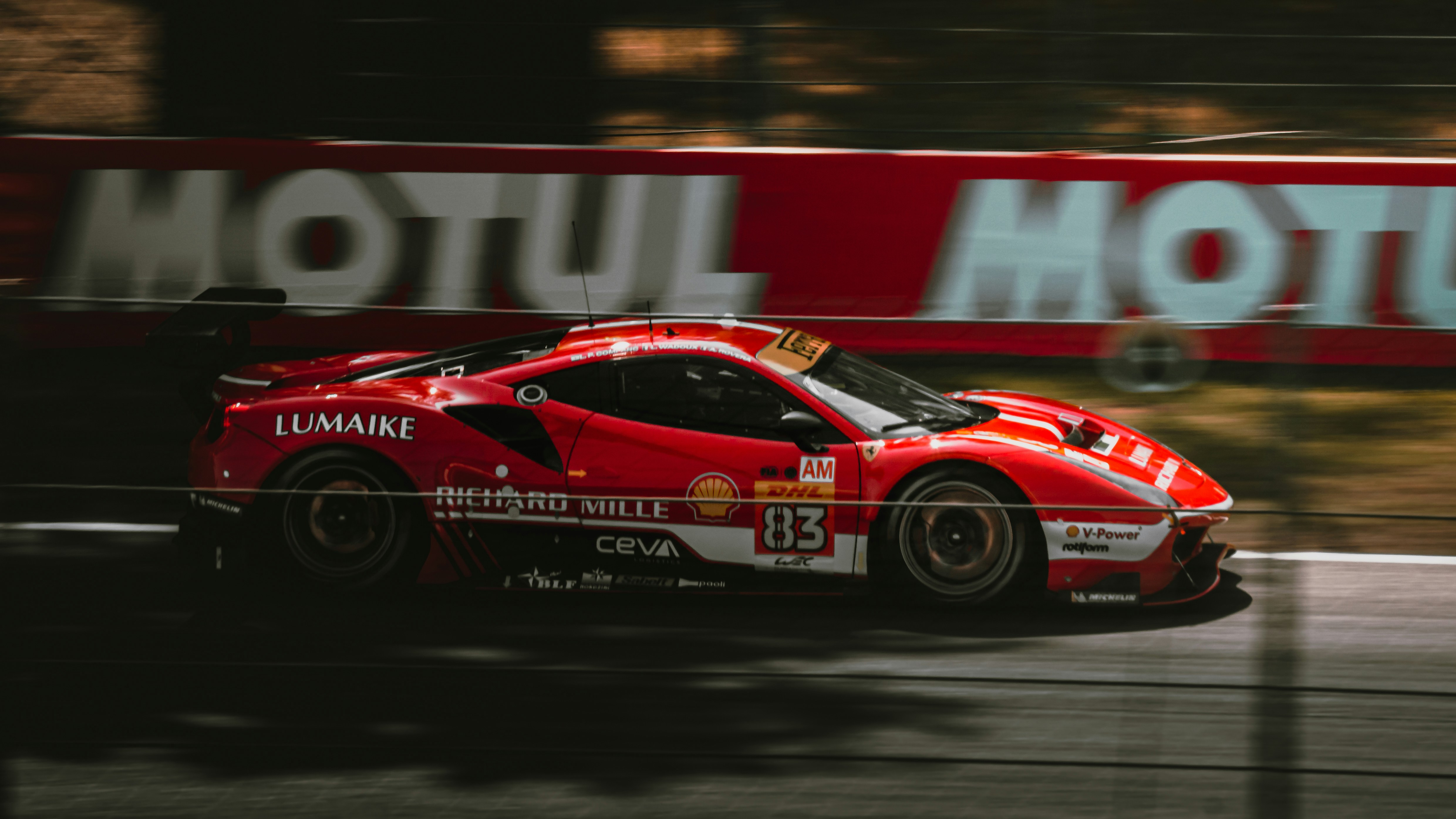 A red race car driving down a race track photo – Free Italy Image on ...